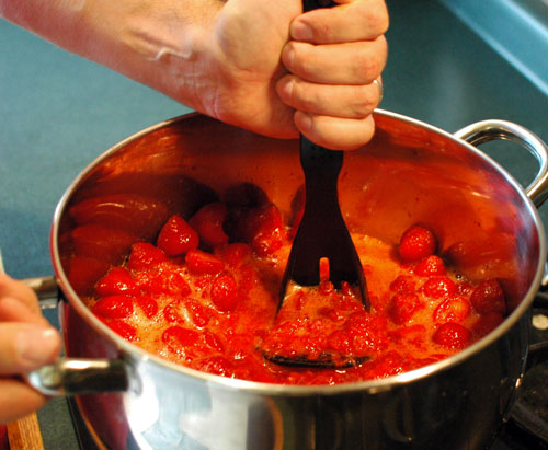 mashing berries for homemade jam