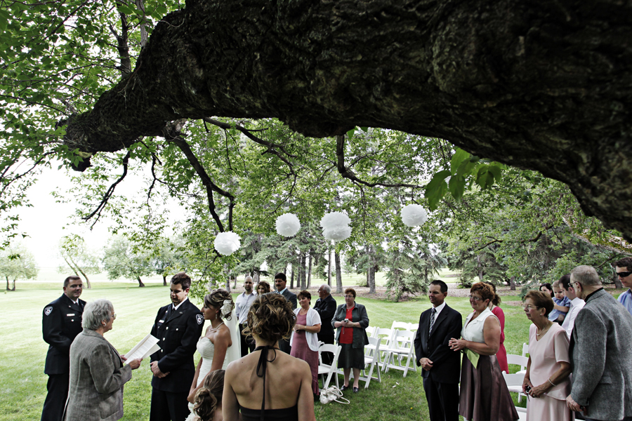 bride and groom exchanging vows under tree