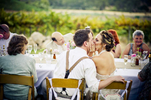 bride and groom kissing at reception table