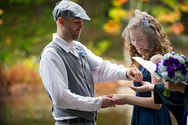 bride and groom exchanging rings in the woods