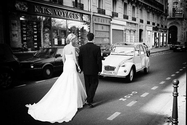 bride and groom walking down parisian street