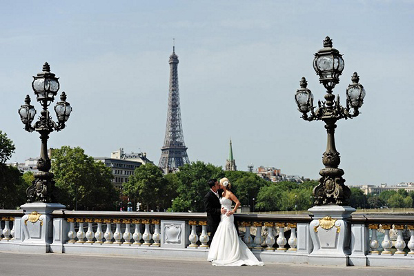 bride and groom kissing in front of eiffel tower