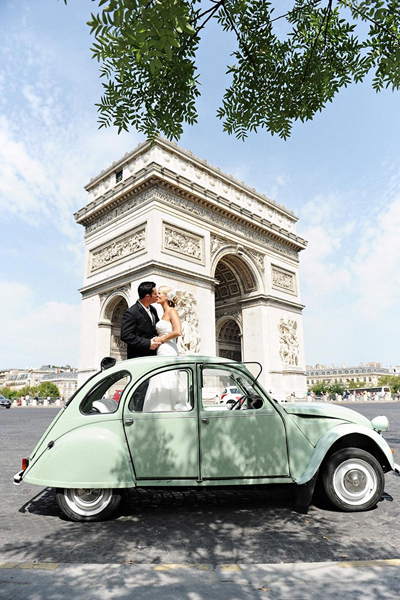 bride and groom in vintage car in front of l'arc de triomphe