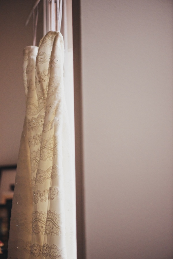 wedding dress hanging in window