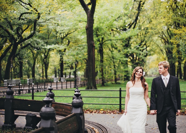 bride and groom walking through central park