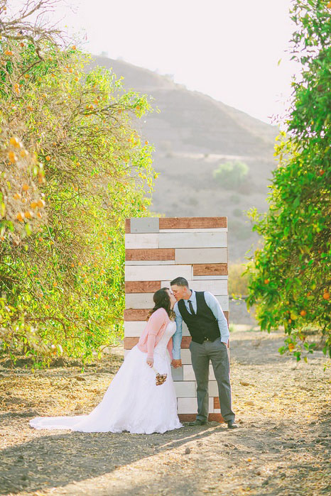 bride and groom kissing in front of ceremony backdrop