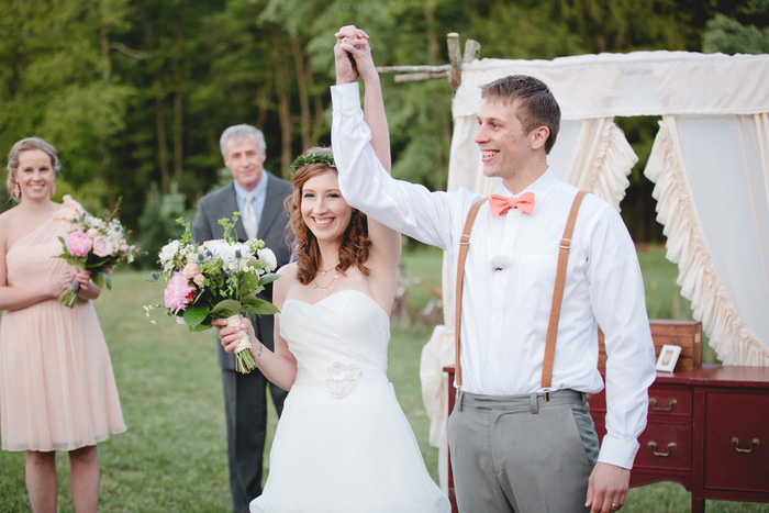 bride and groom with arms raised in victory