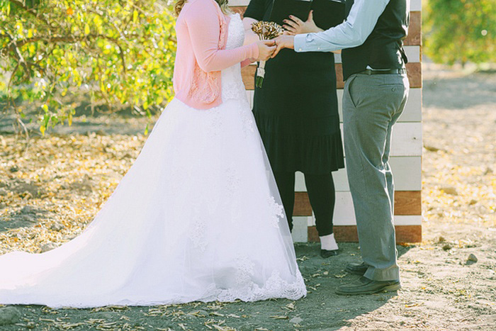 bride placing ring on groom's finger