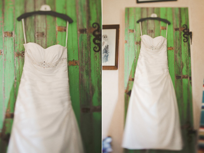 wedding dress hanging on green door