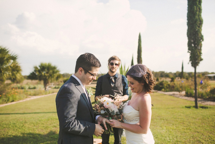 bride putting ring on groom's finger