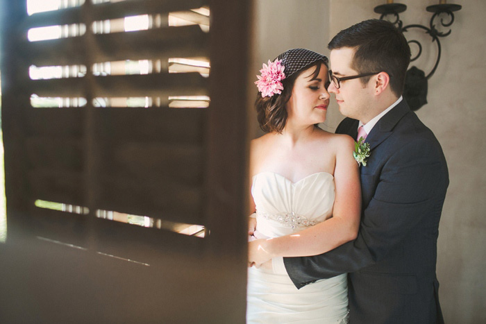 bride and groom portrait behind wooden shutter