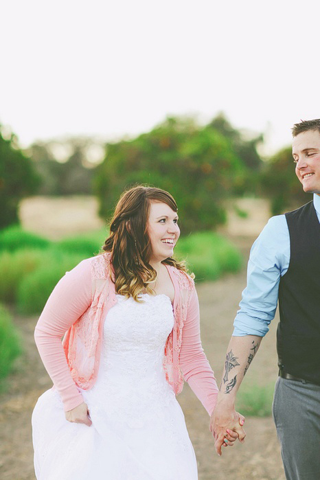 bride and groom walking through orange grove