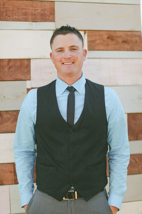 groom in blue shirt and black vest