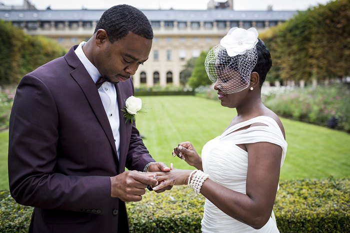 groom putting ring on bride's finger