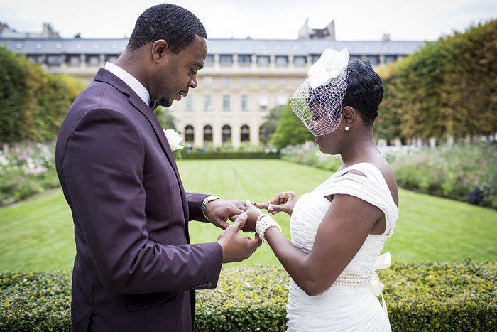 bride putting ring on groom's finger