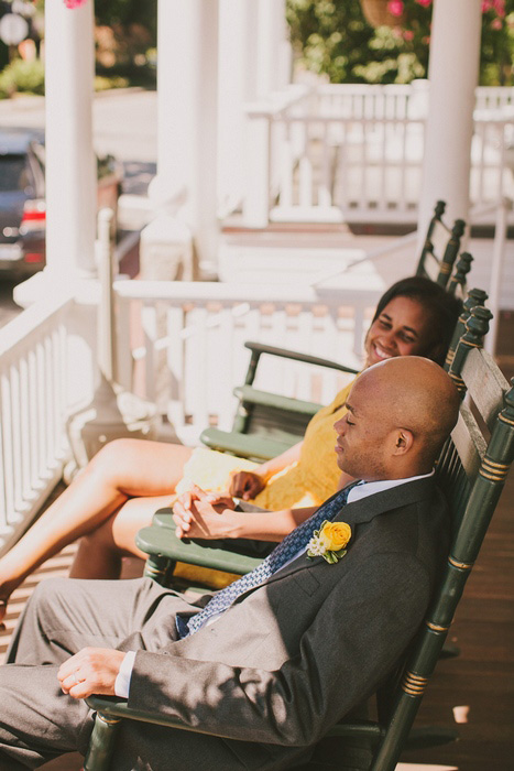 bride and groom in rocking chairs on inn porch