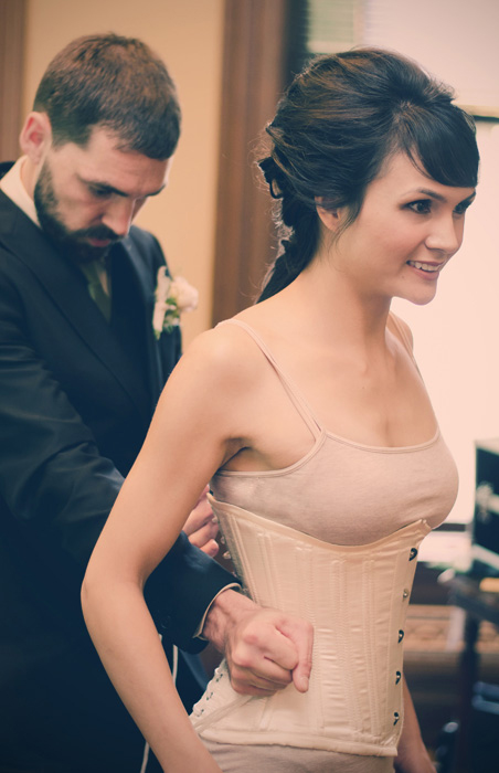 groom tying bride's corset