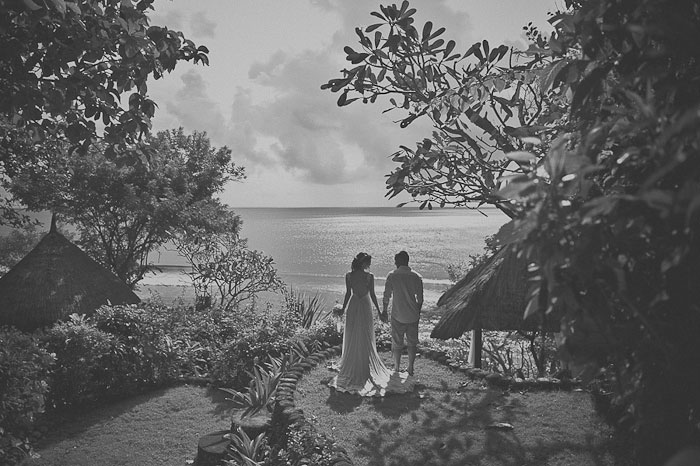 bride and groom standing by the ocean