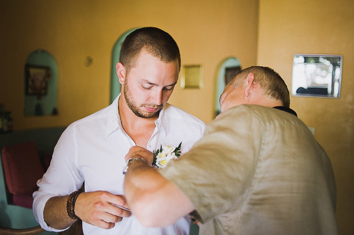 groom pinning on boutonniere