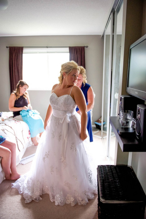 bride getting into her wedding dress