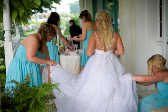 bridesmaids helping bride with her dress