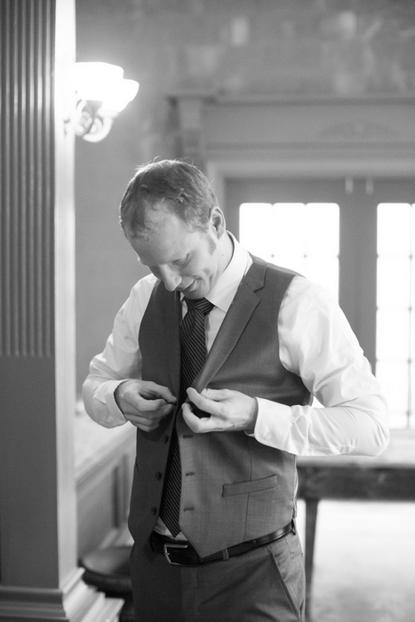 groom buttoning his vest