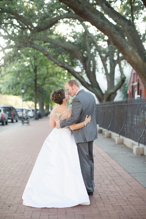 bride and groom kissing on the street