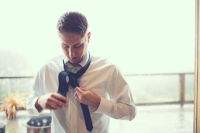 Groom tying hi tie