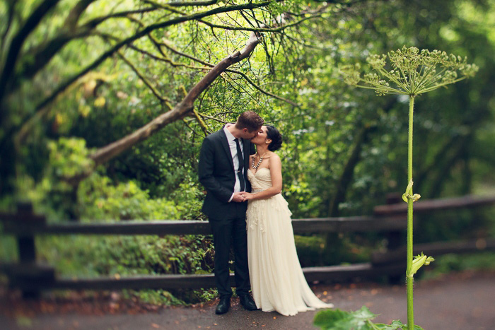 bride and groom kissing in the forest