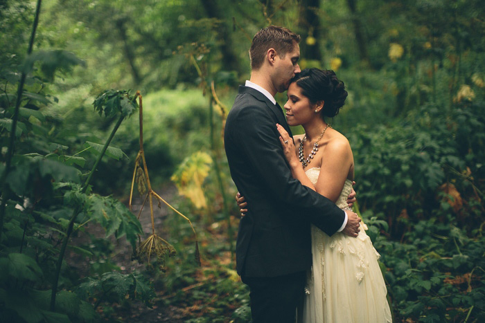 bride and groom embracing in the woods