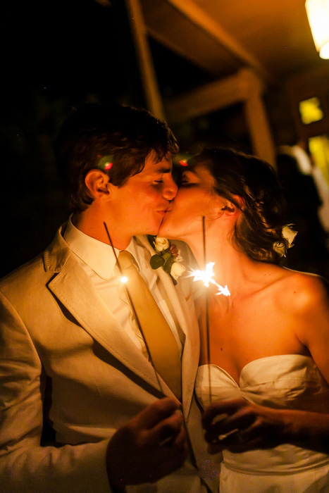 bride and groom kissing with sparklers