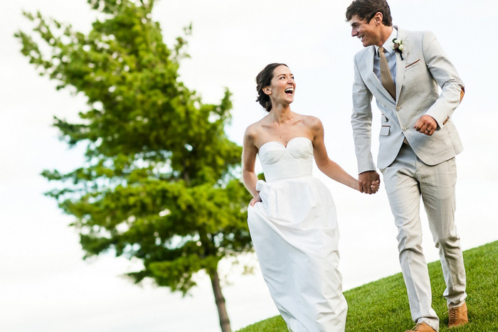 bride and groom running on the golf course