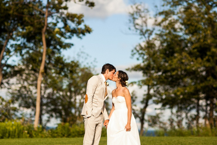 bride and groom kissing on the golf course