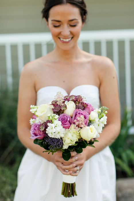 bride with purple and white wedding bouquet