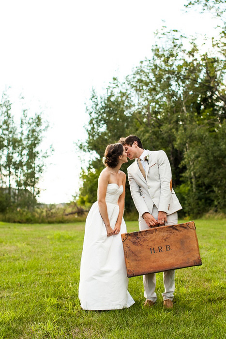 groom holding vintage suitcase