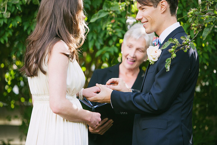 groom putting ring on bride's finger