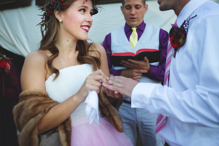 bride putting ring on groom's finger