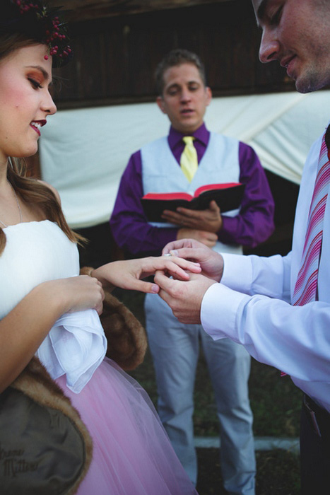 groom putting ring on bride's finger