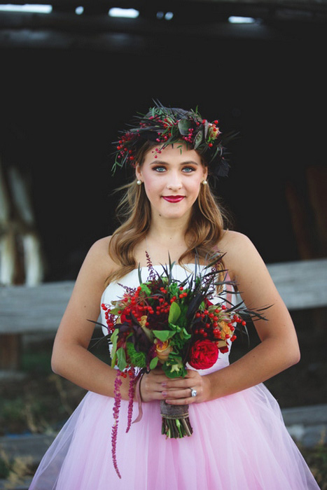 bride with red orange and green wedding bouquet