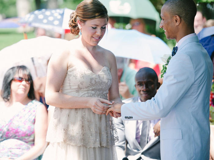 bride putting ring on groom's finger