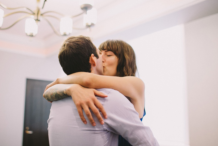 bride and groom kissing in city hall