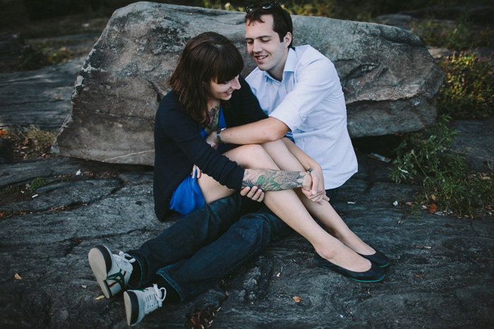 bride and groom sitting on a rock