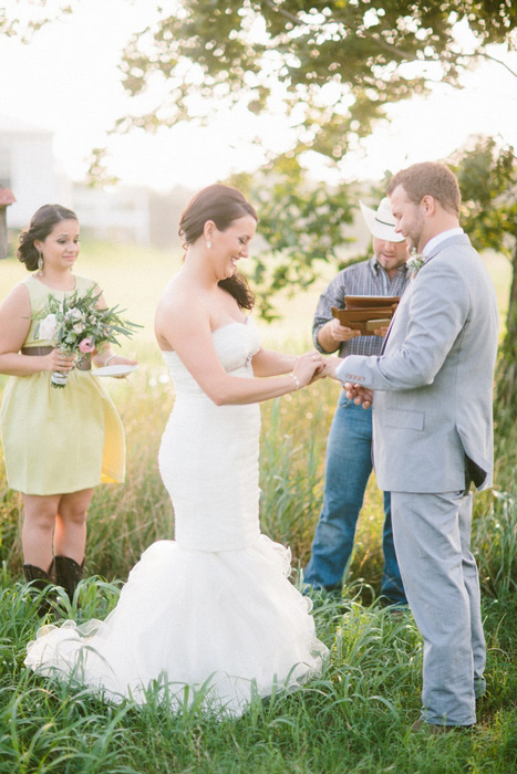 bride putting ring on groom's finger