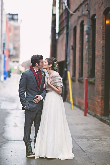 bride and groom kissing in alleyway