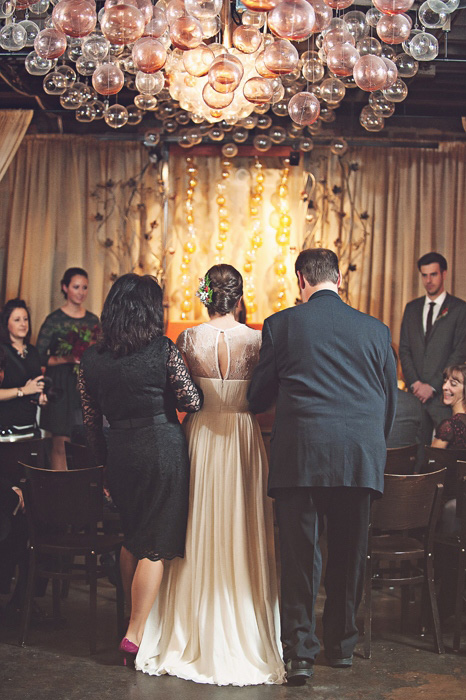 bride walking down aisle with her parents