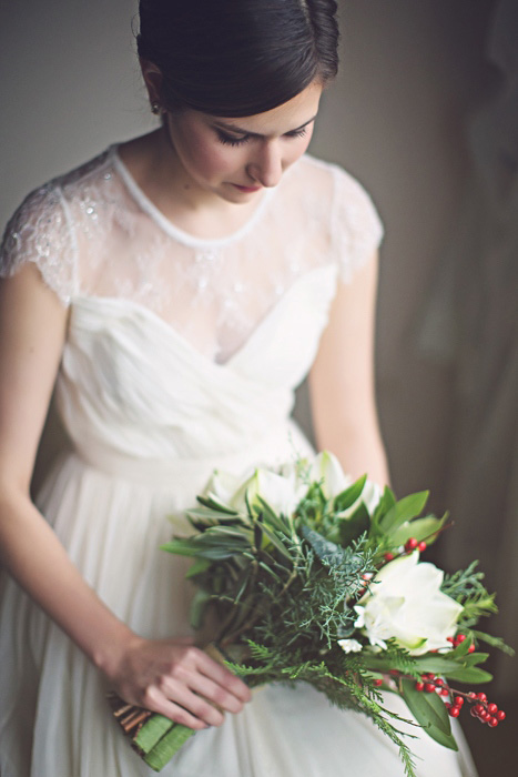 bride in dress with short sleeves and winter bouquet