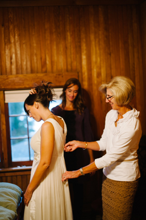 mother of the bride zipping up the bride's dress