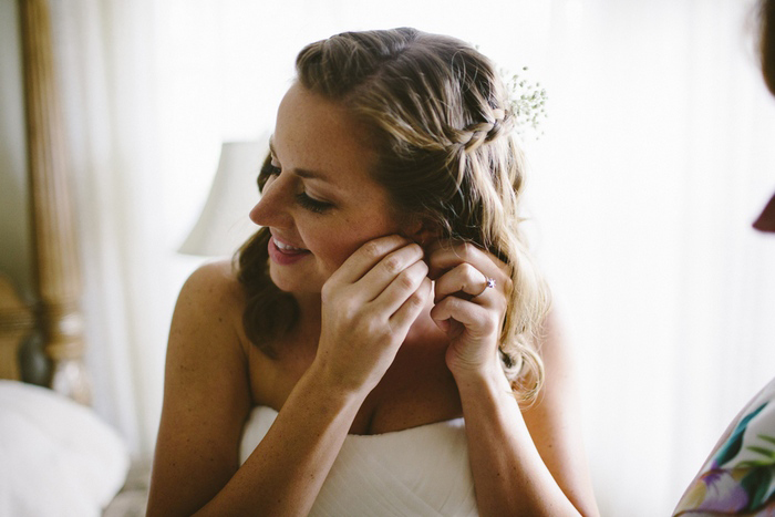 bride putting on her earrings