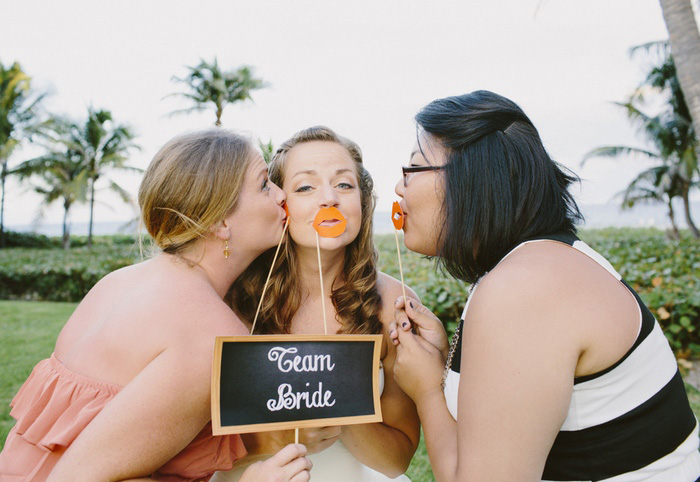 bride and friends with photo booth props