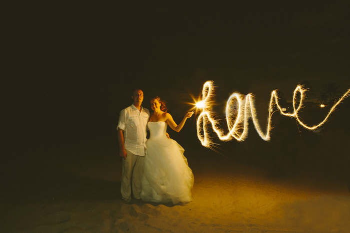 bride and groom with sparklers on the beach